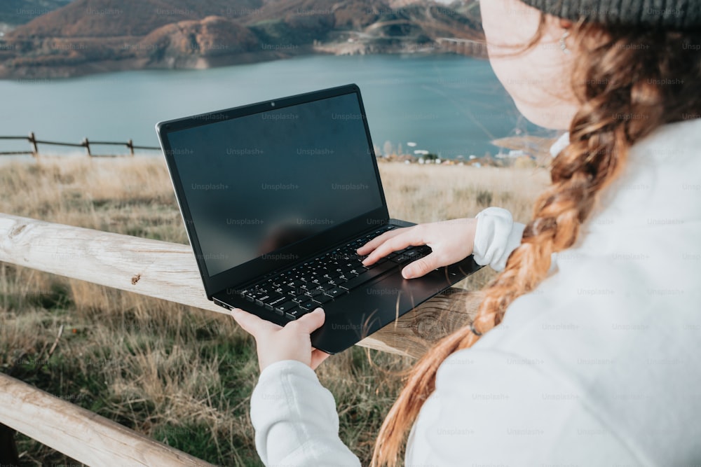 Una mujer sosteniendo una computadora portátil en sus manos