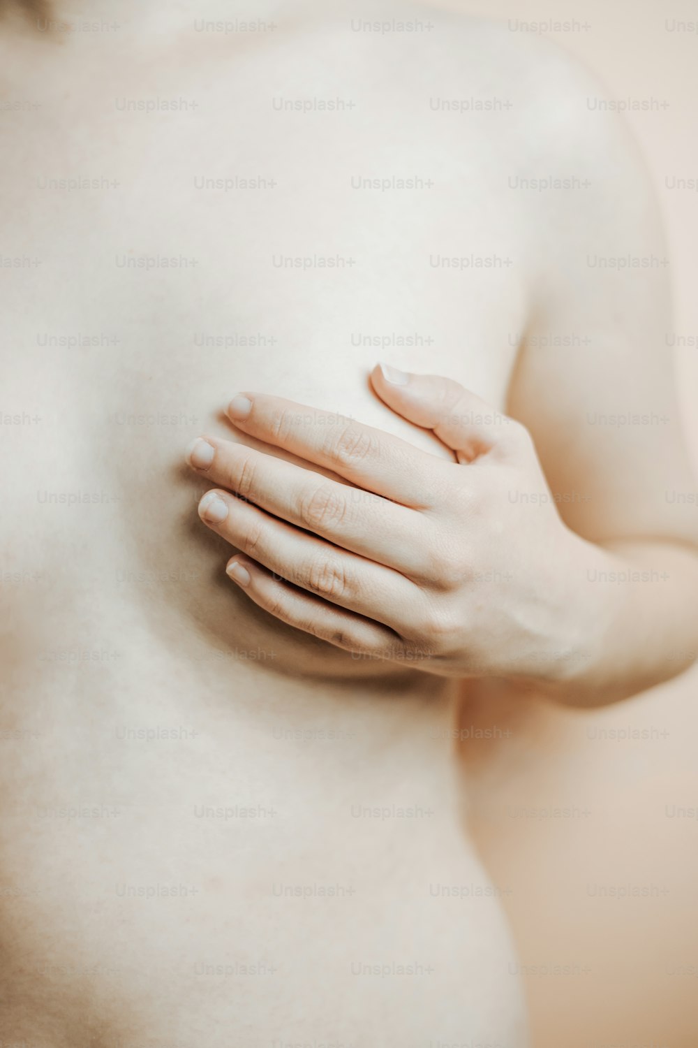 a close up of a woman's breast with her hands on her chest