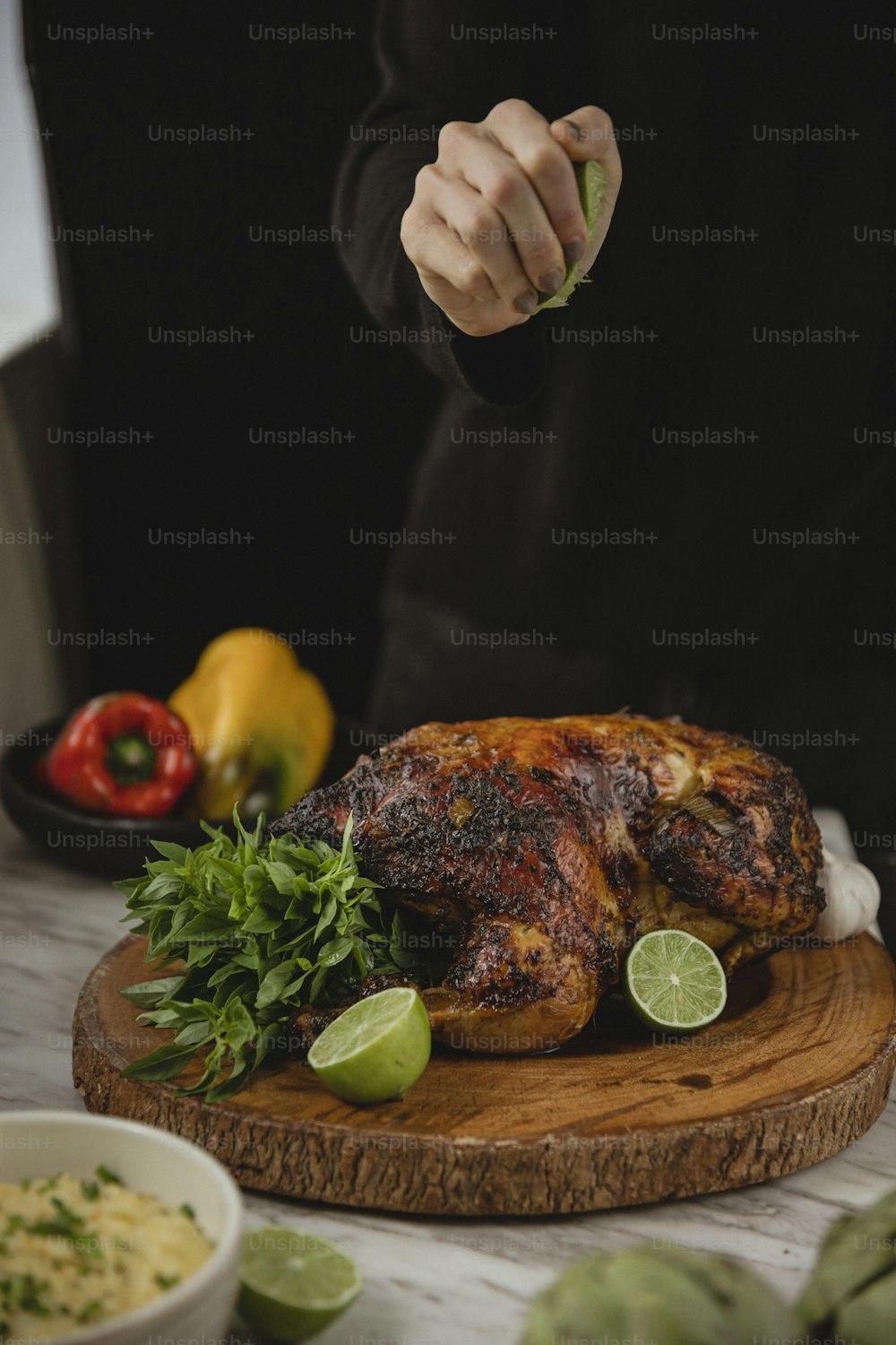 une personne coupant un poulet sur une planche à découper