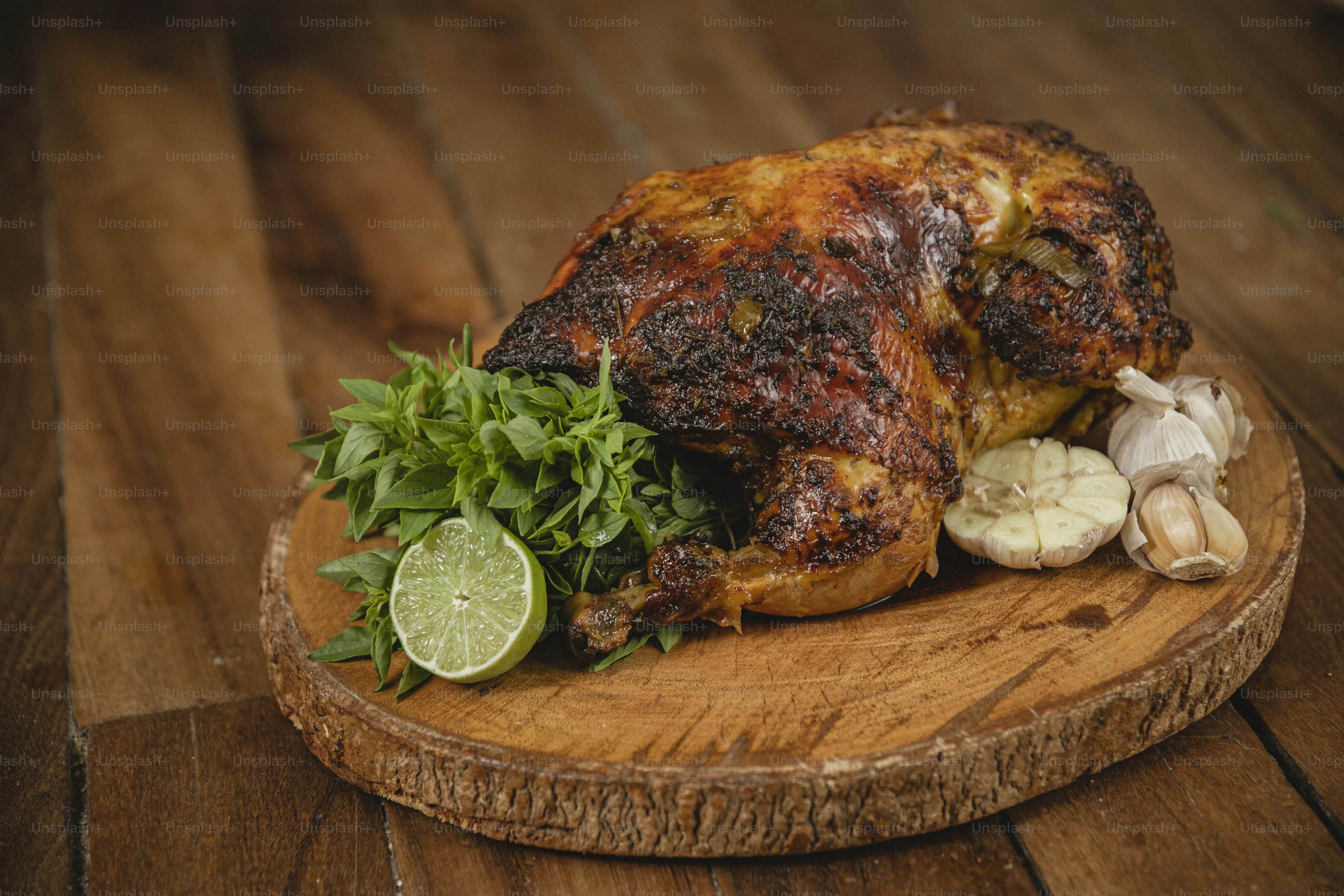 um frango inteiro em uma tábua de corte com ervas e alho