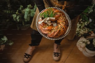 a person holding a plate of food on a wooden floor
