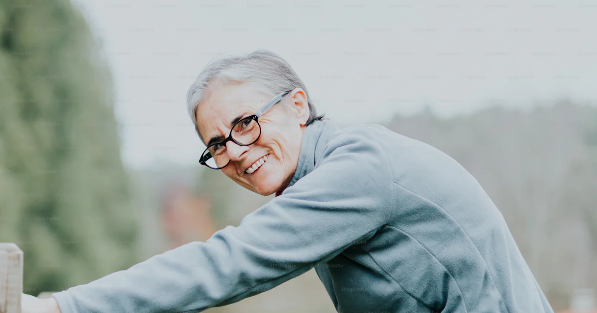 A woman leaning on a wooden fence with her leg in the air photo ...