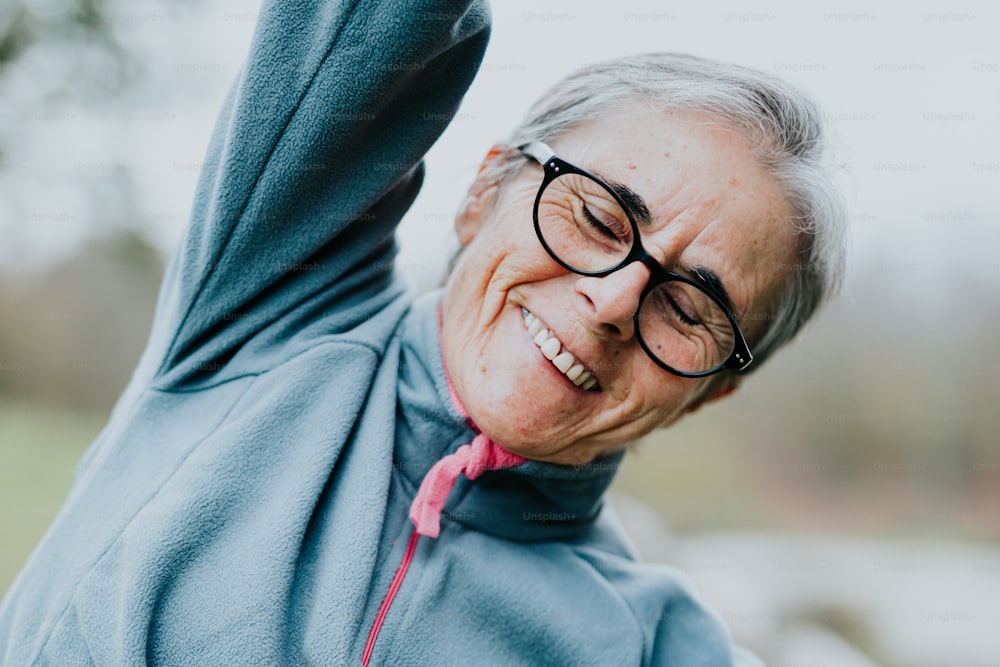 an older woman wearing glasses and a blue sweatshirt