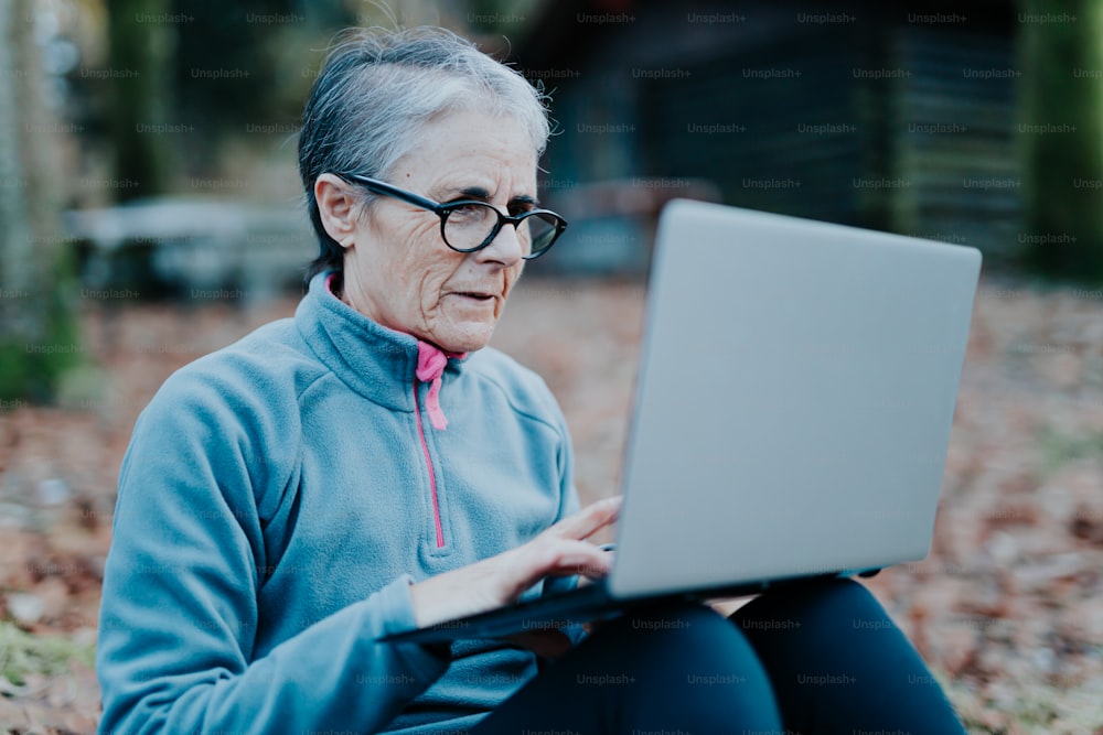 a woman sitting on the ground using a laptop computer