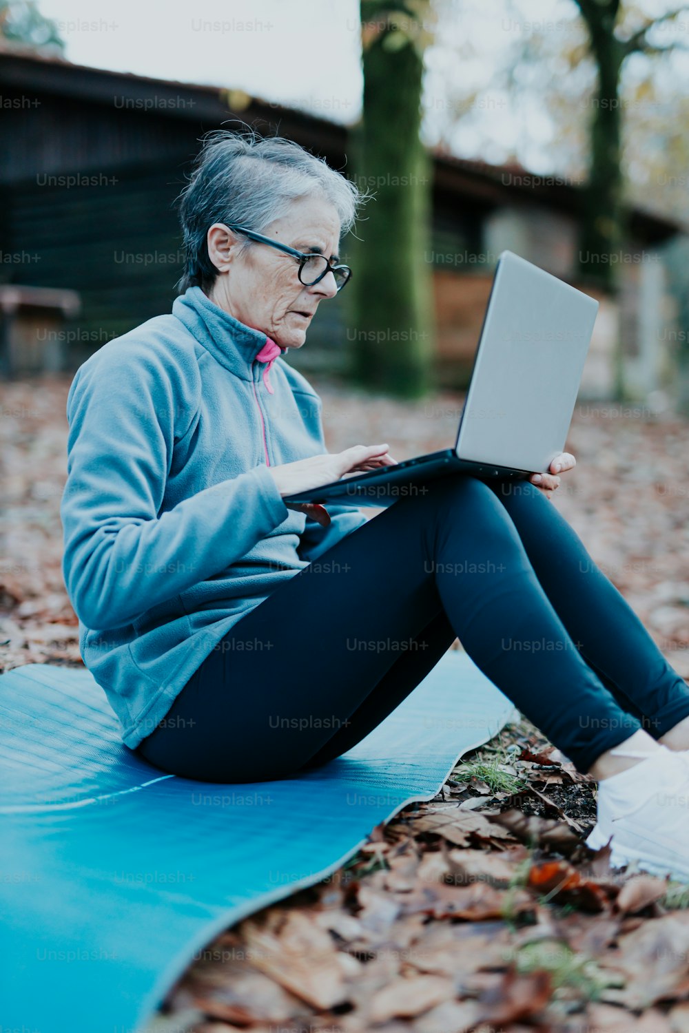a woman sitting on the ground using a laptop