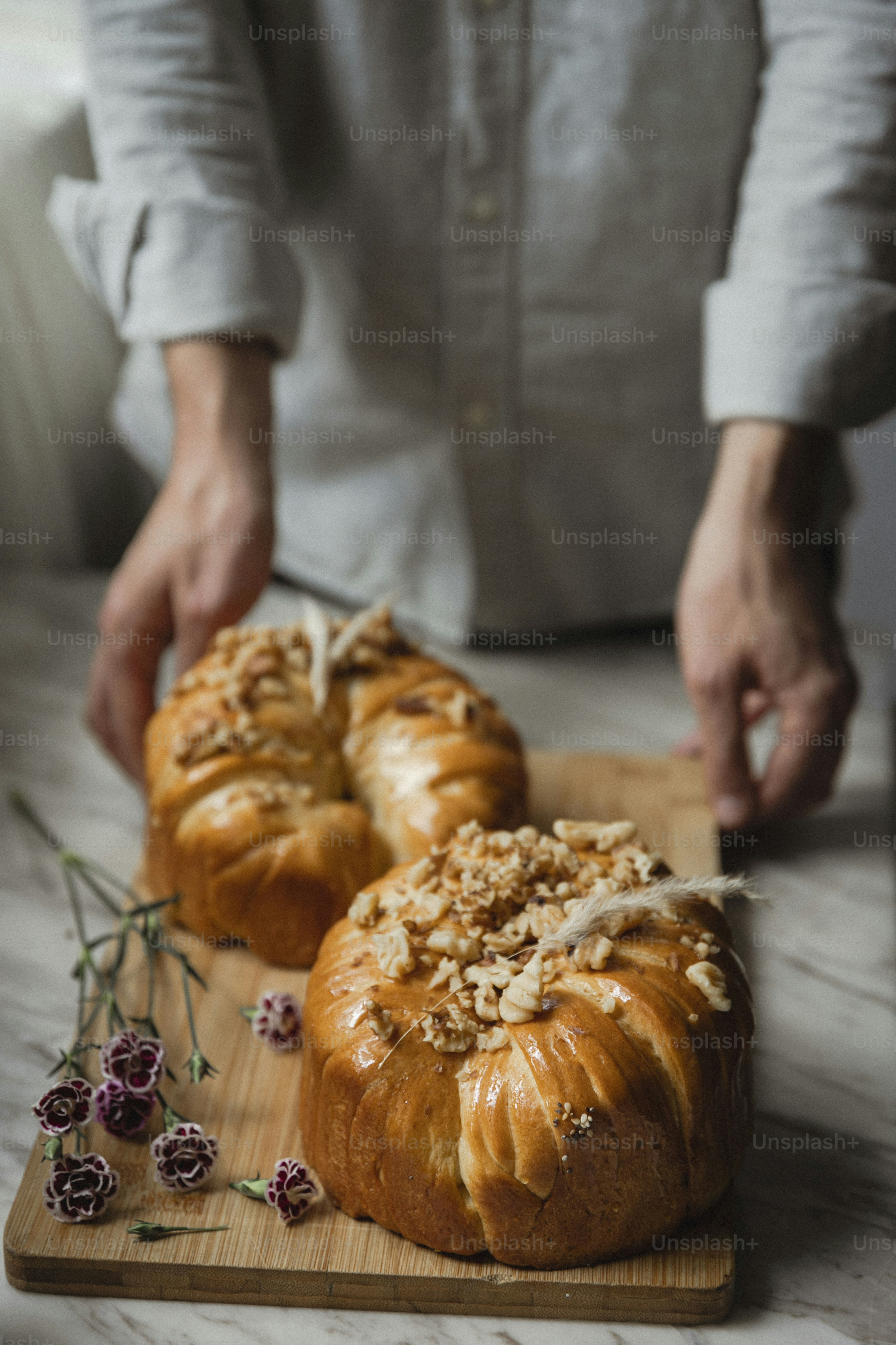 a person cutting a loaf of bread on a cutting board