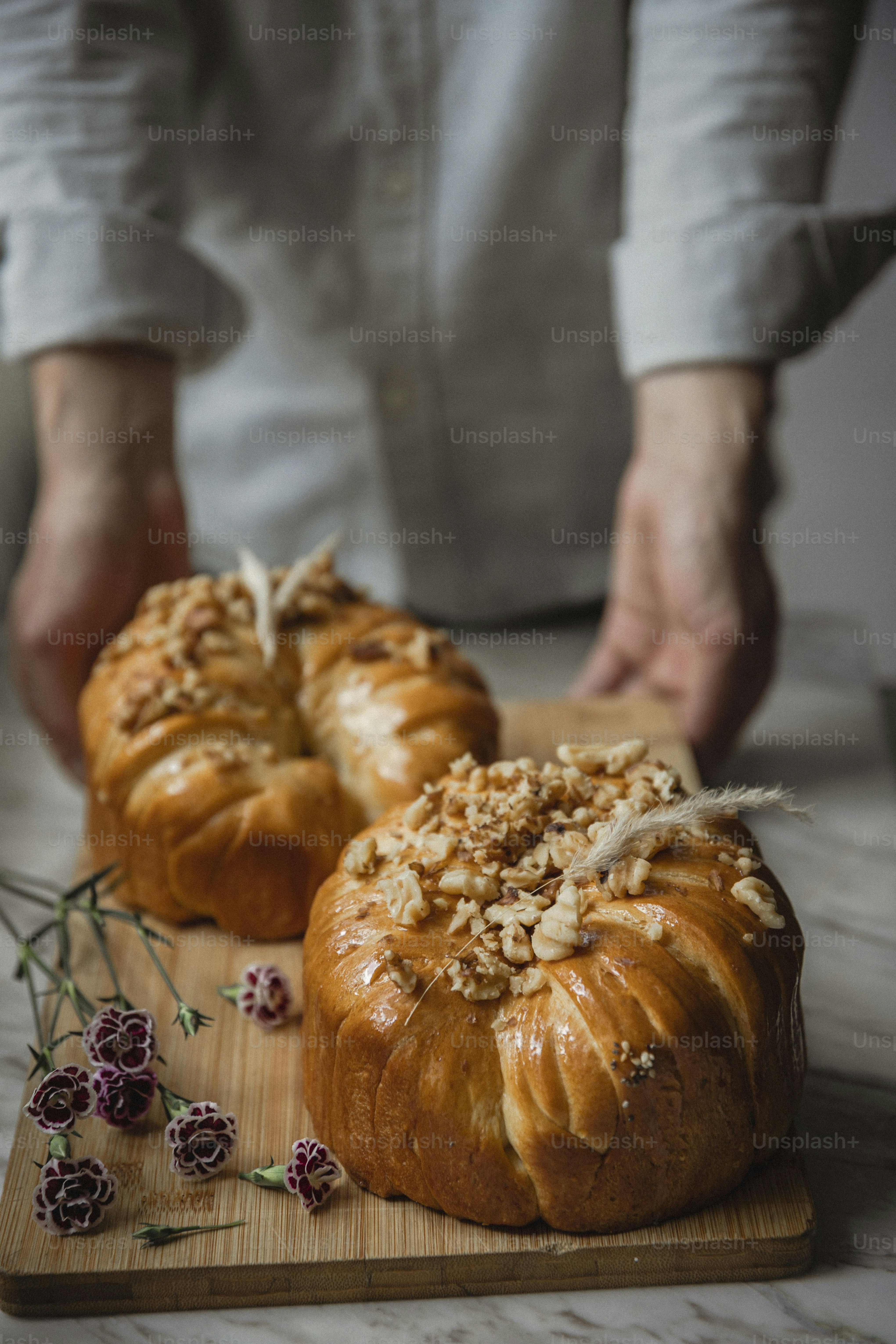 a person cutting a loaf of bread on a cutting board