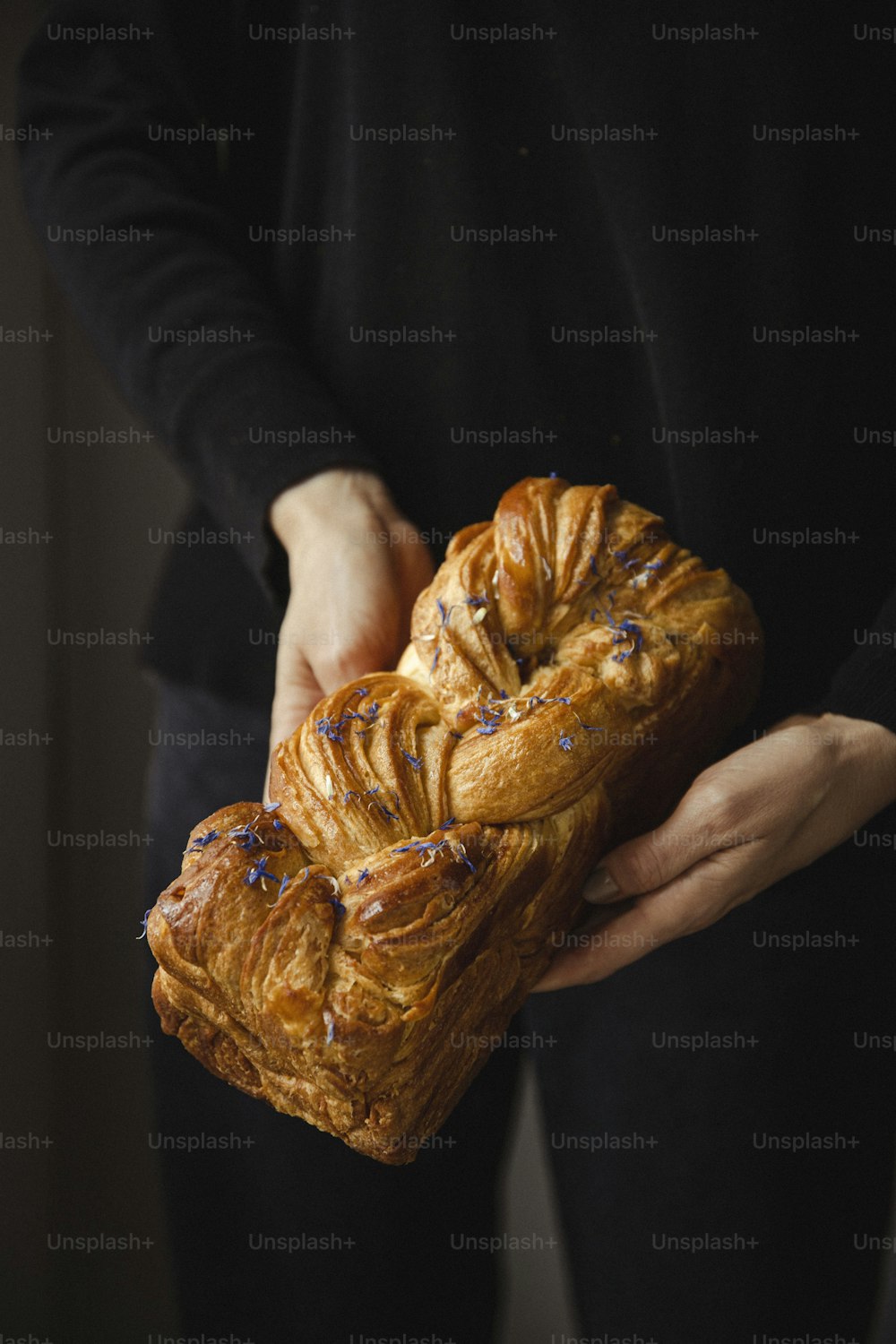 a person holding a piece of bread in their hands