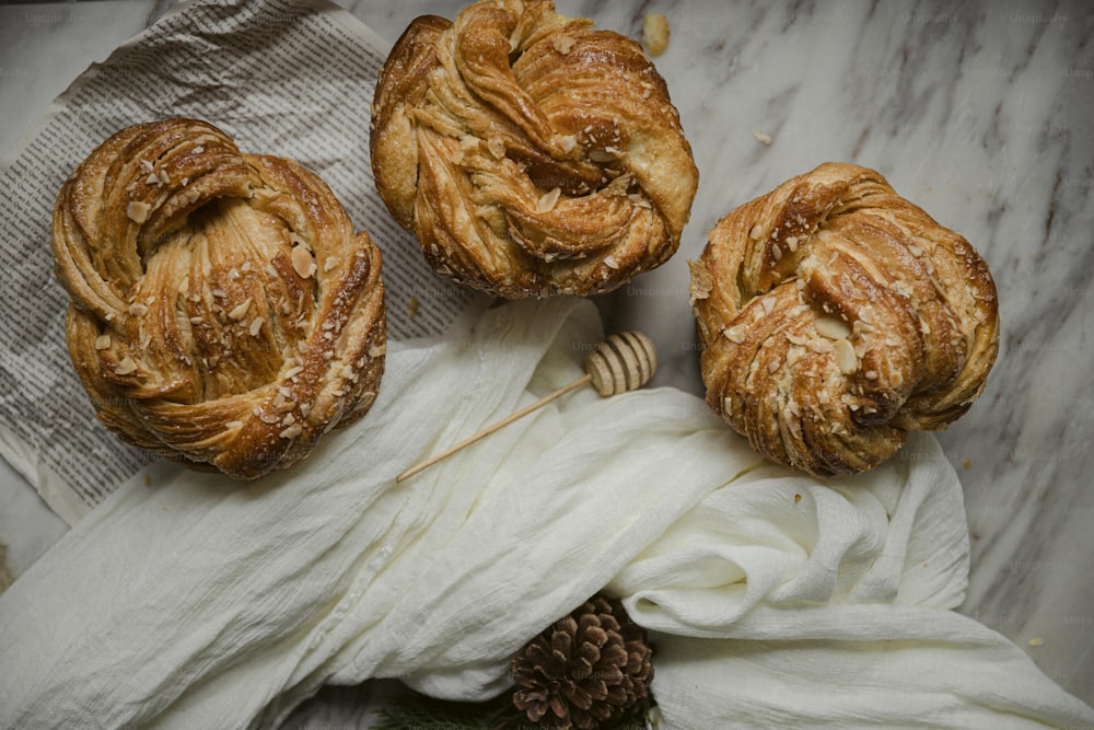 three pastries sitting on top of a white cloth