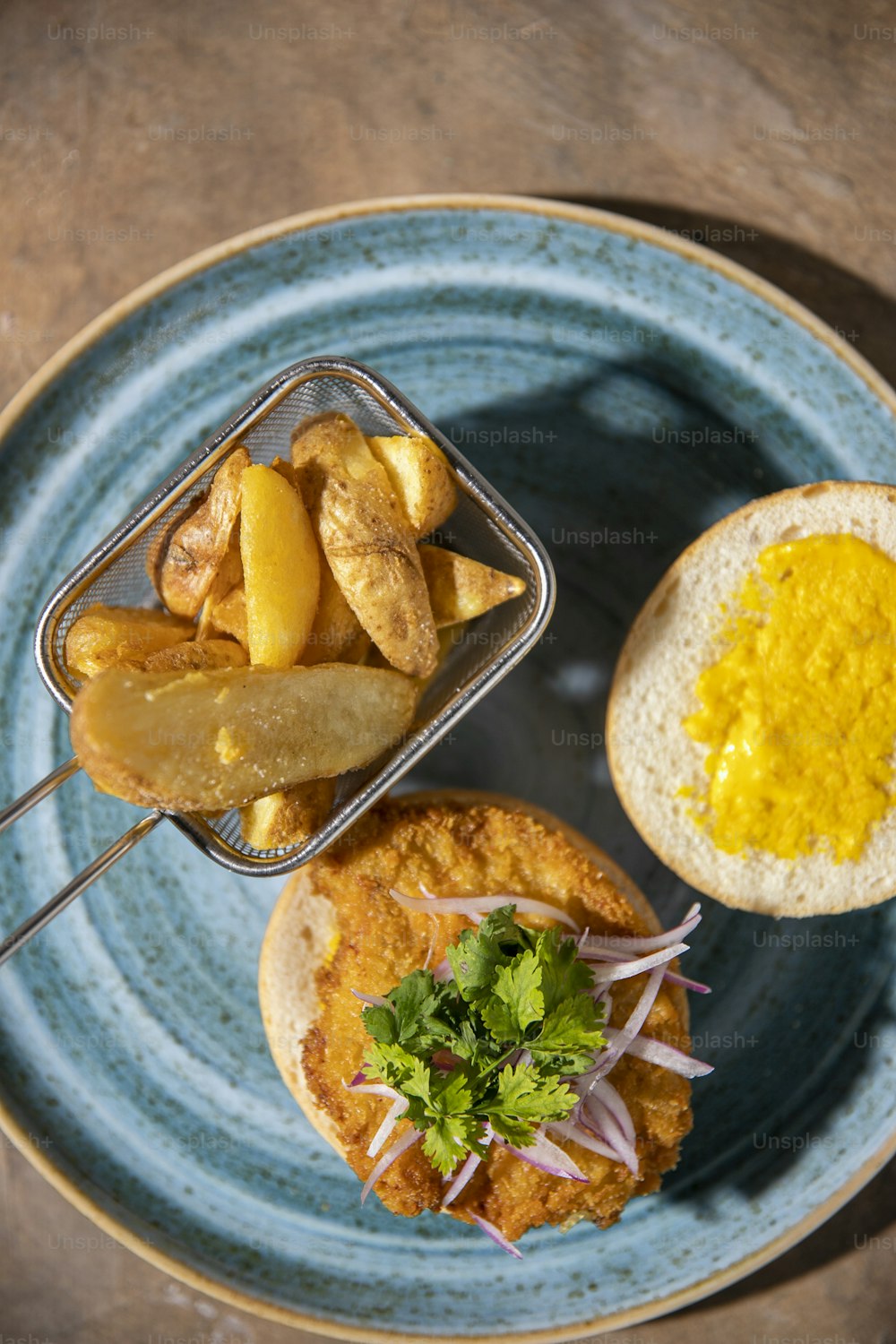 um prato azul coberto com um sanduíche e um ovo frito