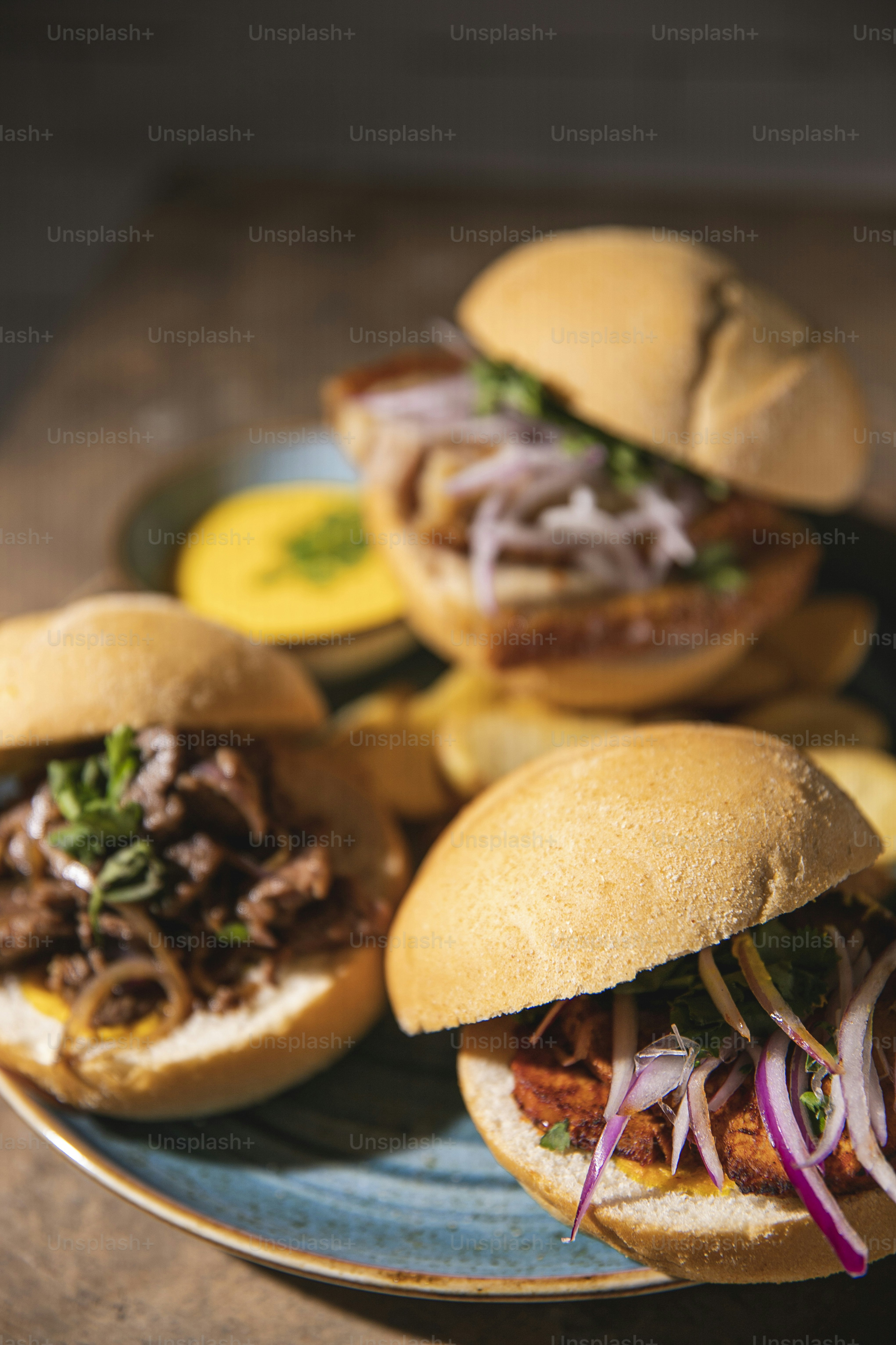 three pulled pork sandwiches on a blue plate