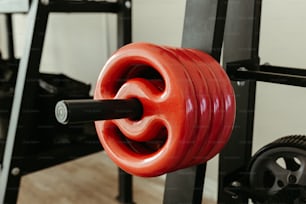a close up of a red barbell in a gym