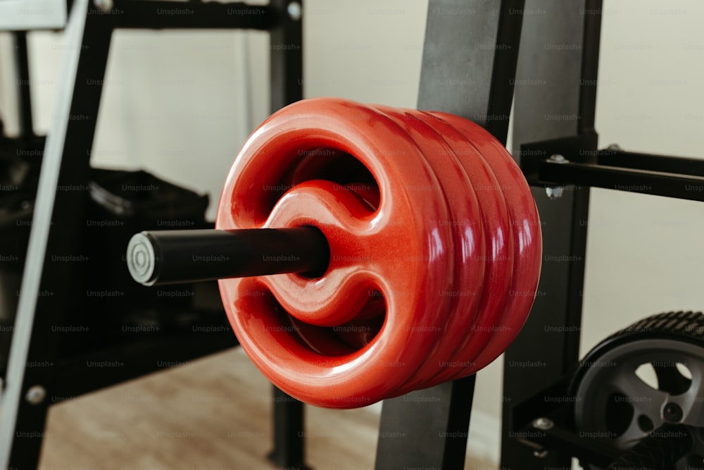 a close up of a red barbell in a gym