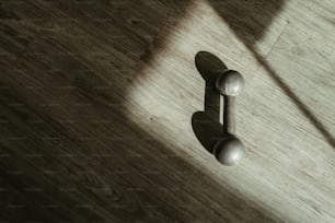 l’ombre d’une poignée de porte sur un plancher en bois