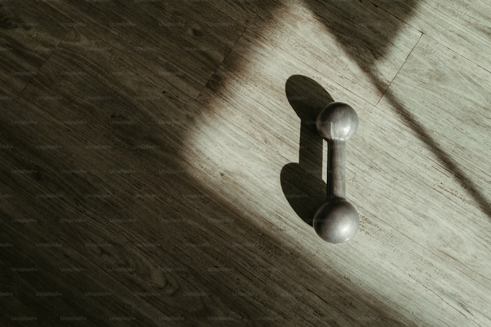 the shadow of a door handle on a wooden floor