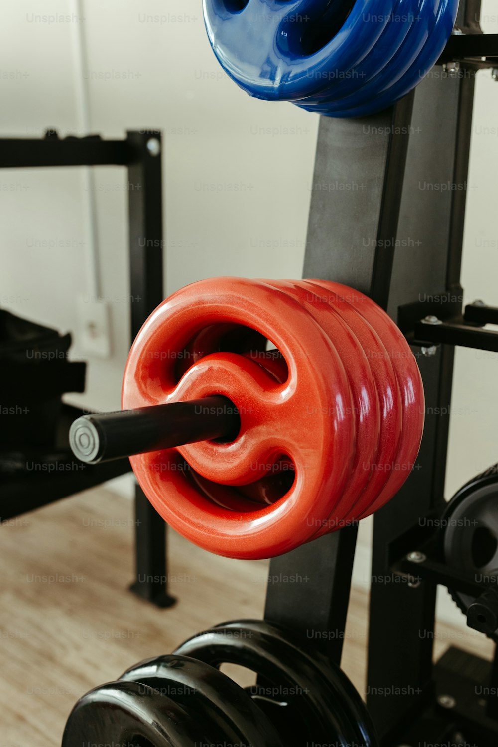 a pair of red and blue dumbbells hanging from a rack