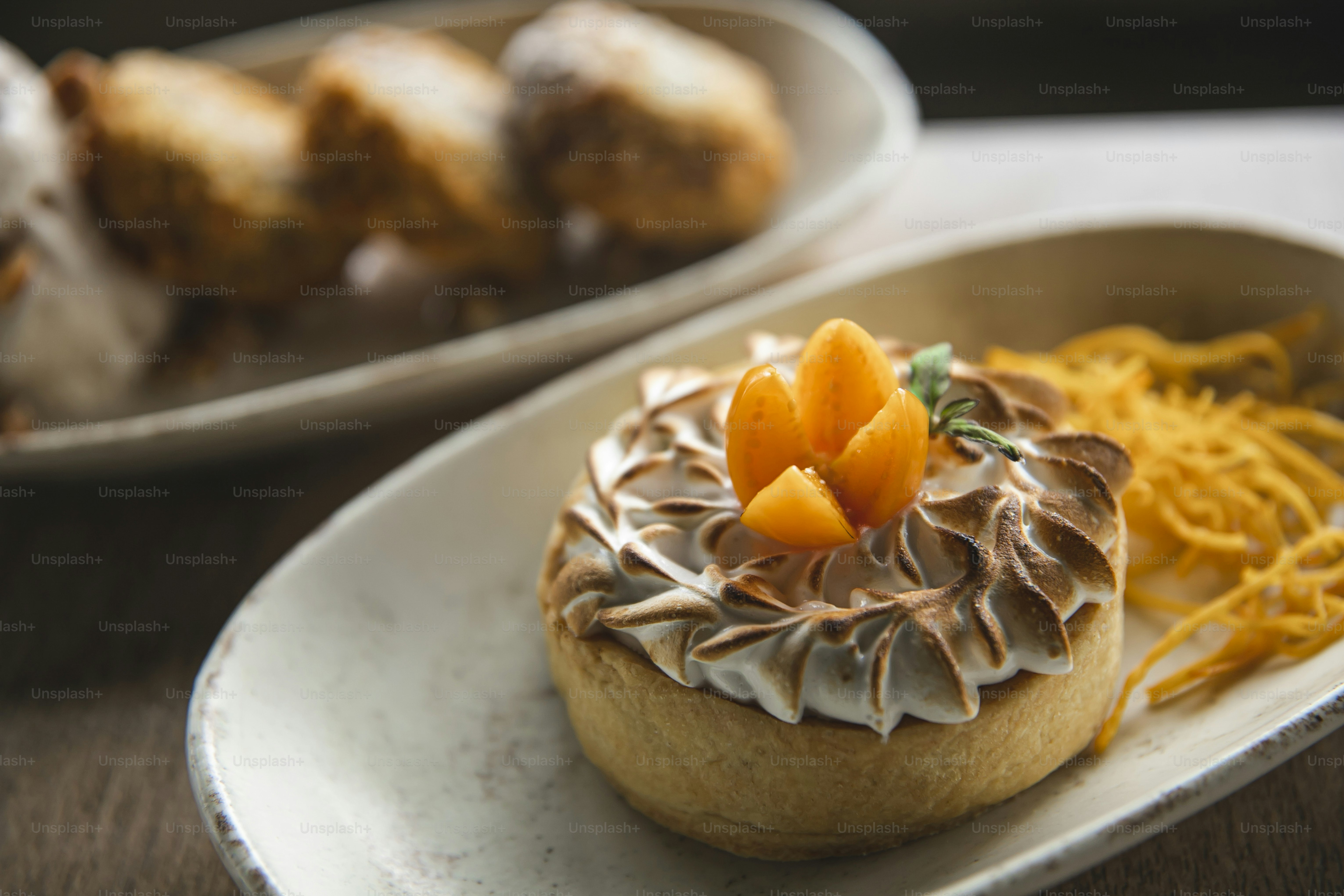 um prato com uma massa ao lado de outro prato com doces