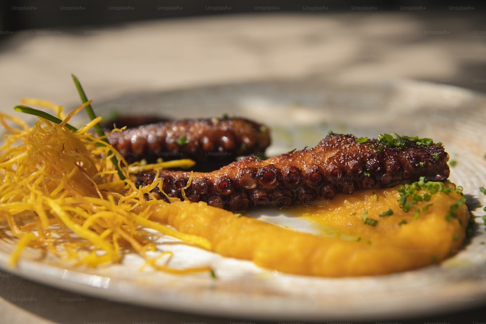 Un plato blanco cubierto con dos salchichas cubiertas de salsa