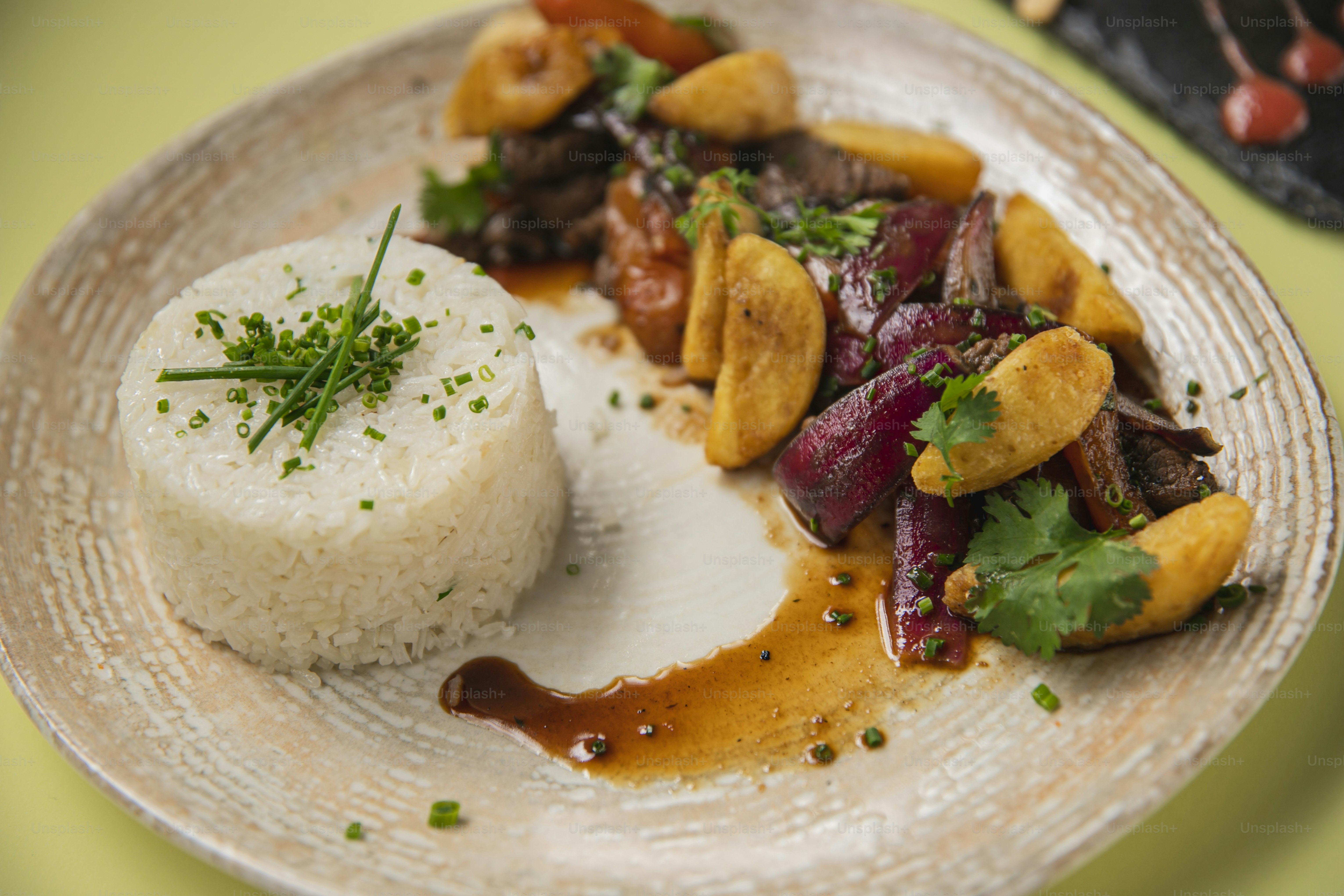 um prato de comida com arroz, carne e legumes