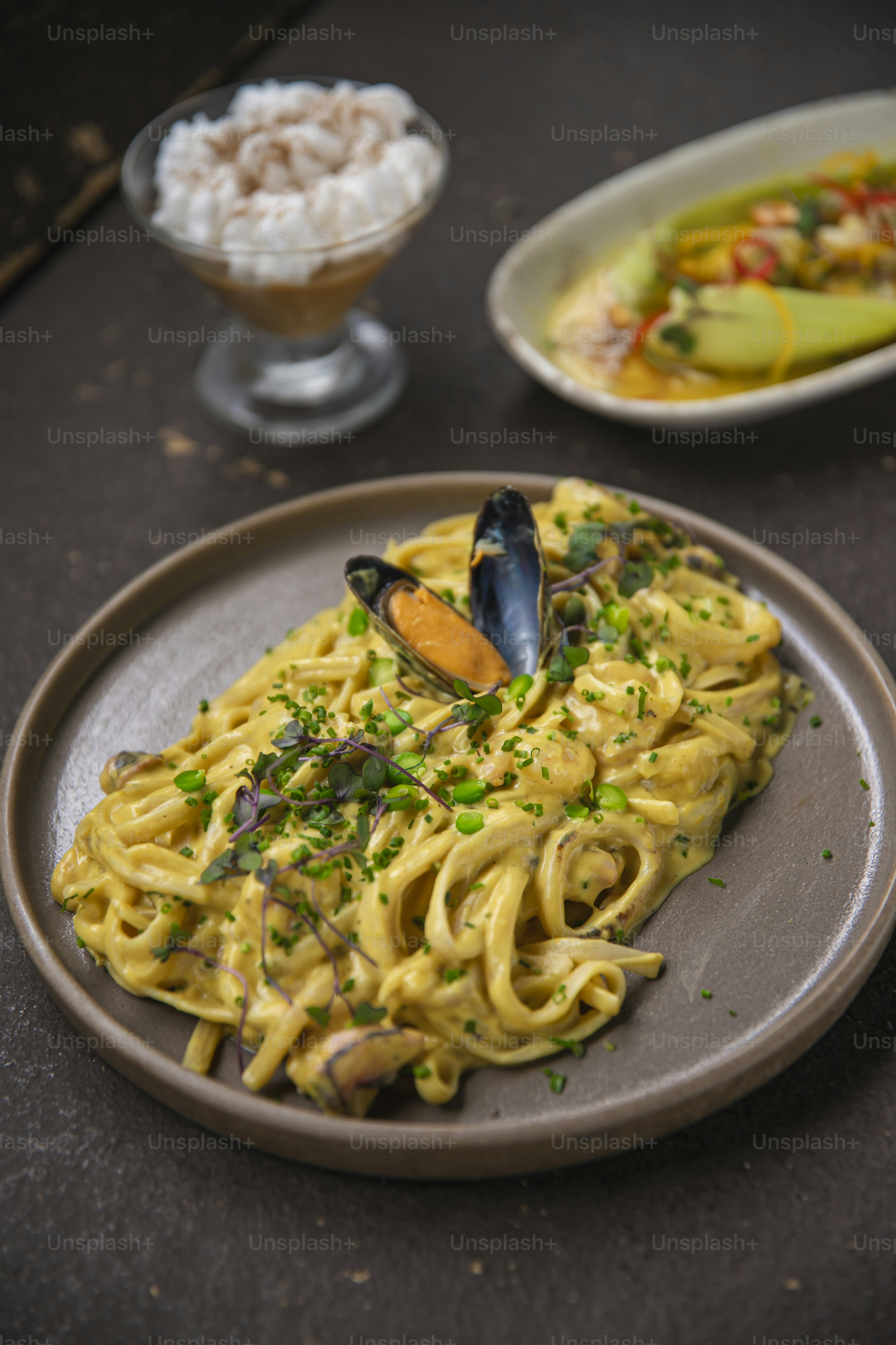 un piatto di pasta con le cozze e una ciotola di riso