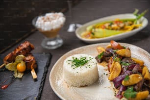 a white plate topped with food next to a bowl of rice