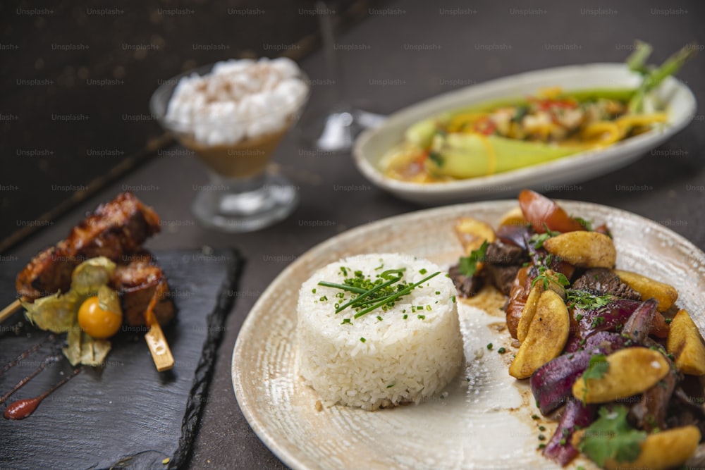 a white plate topped with food next to a bowl of rice