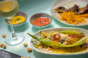 a table topped with plates of food and a glass of wine