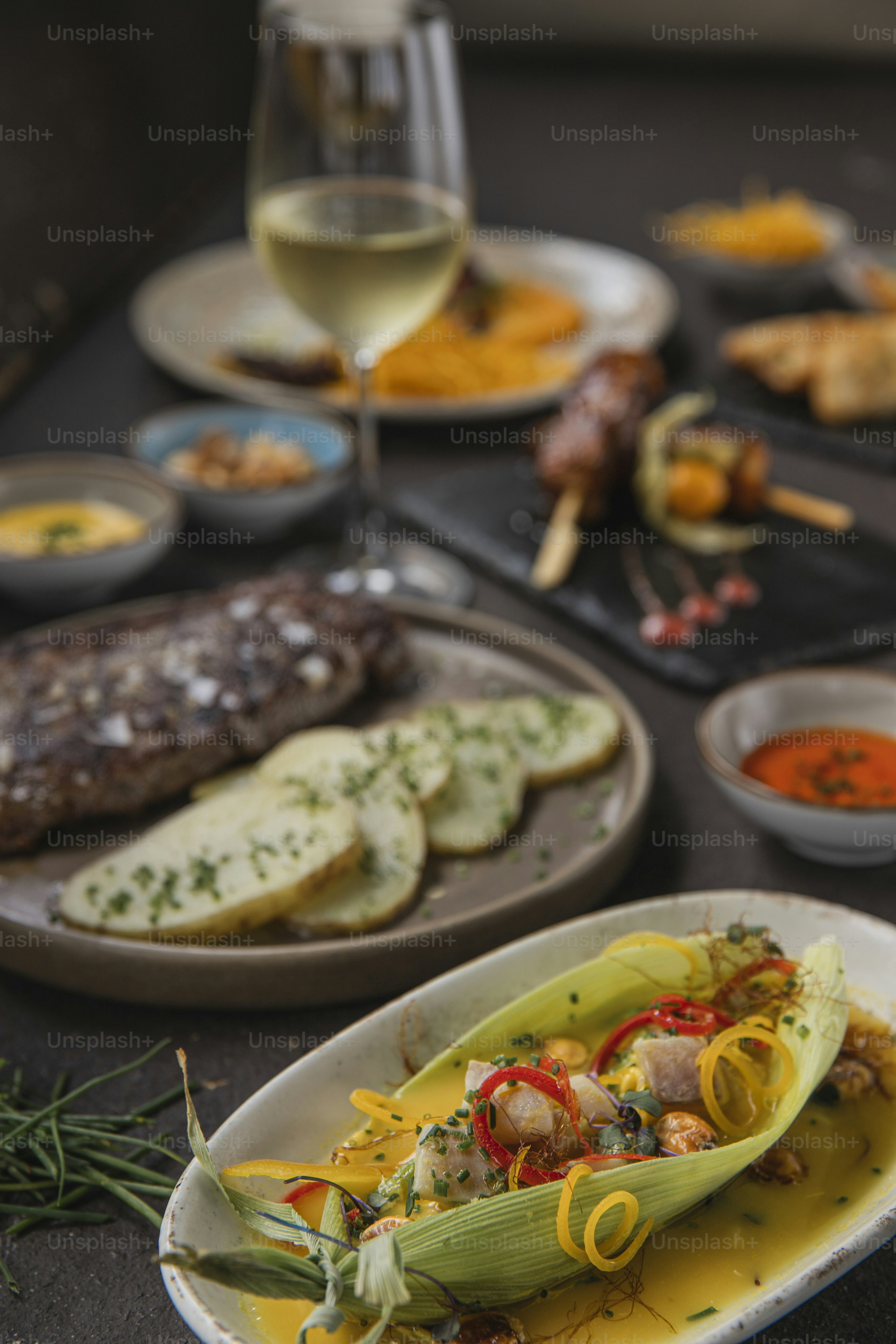 una mesa cubierta con platos de comida y una copa de vino