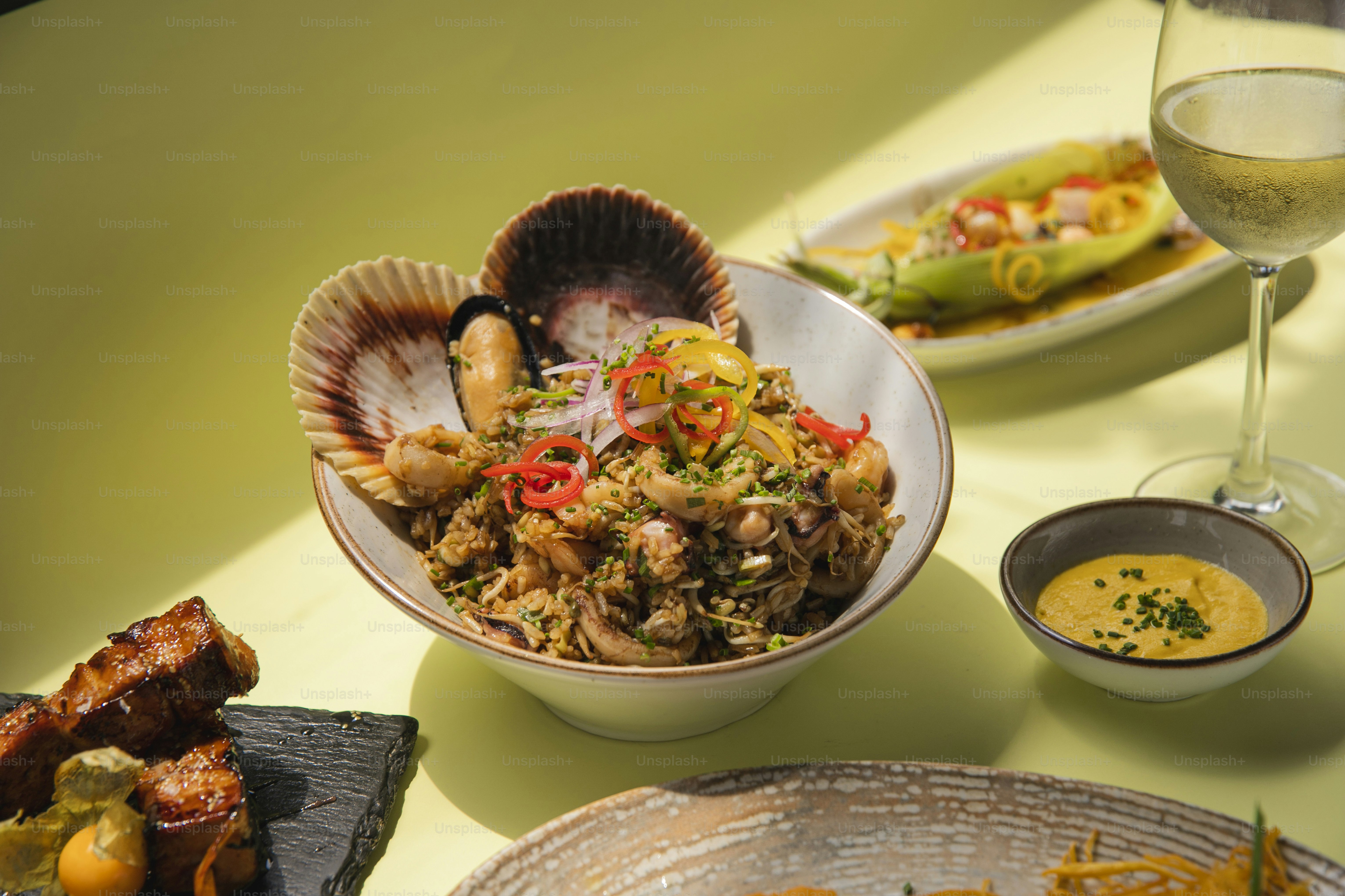 a table topped with plates of food and a glass of wine