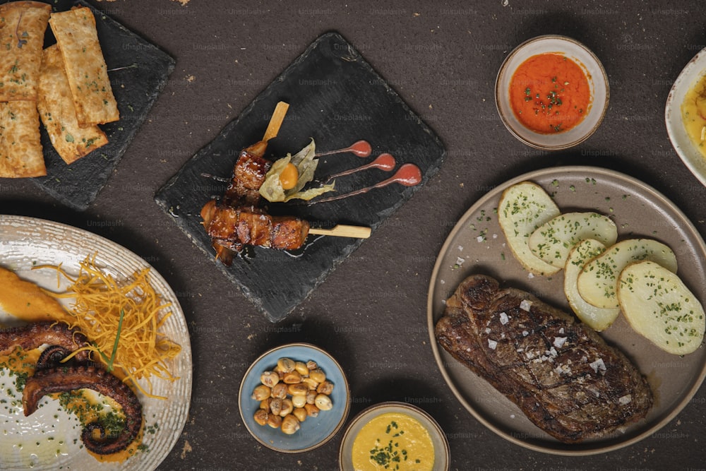 a table topped with plates of food and condiments