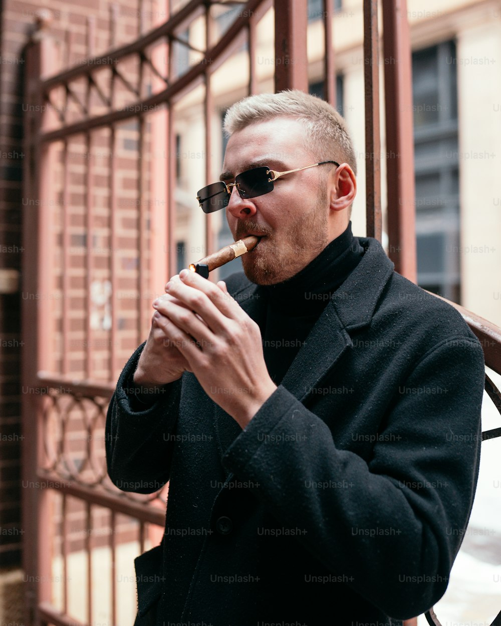 Un uomo in un cappotto nero che fuma una sigaretta