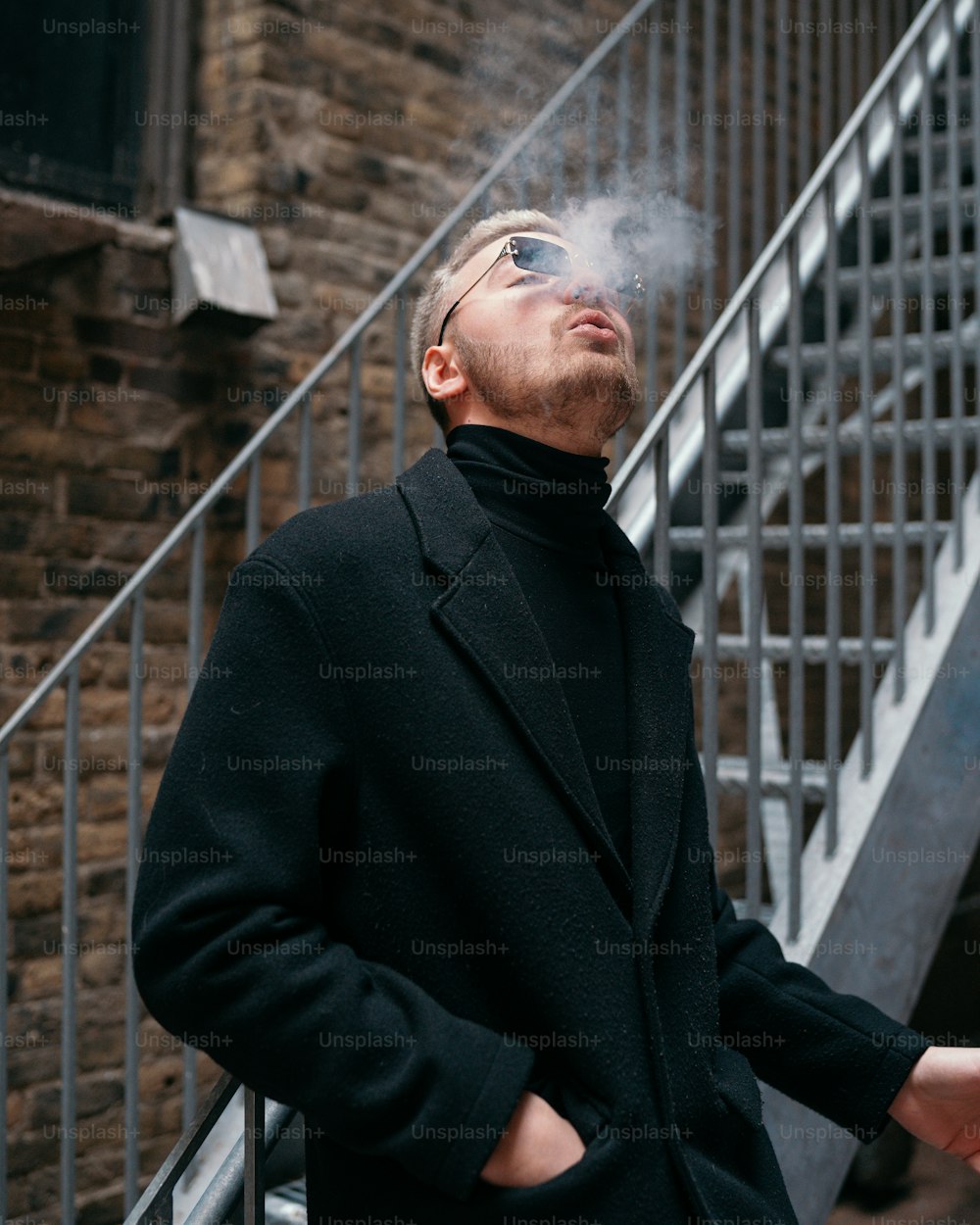 a man in a black coat smoking a cigarette
