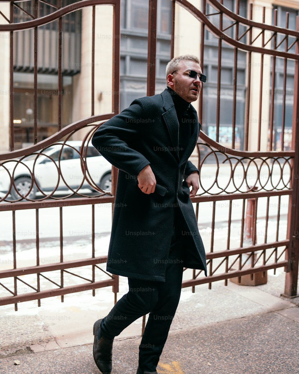 a man in a black coat is walking down the street