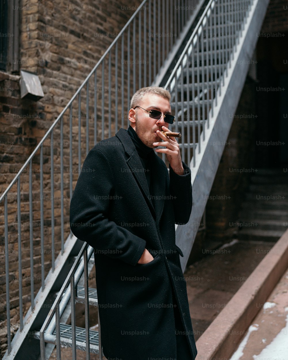 a man in a black coat smoking a cigarette