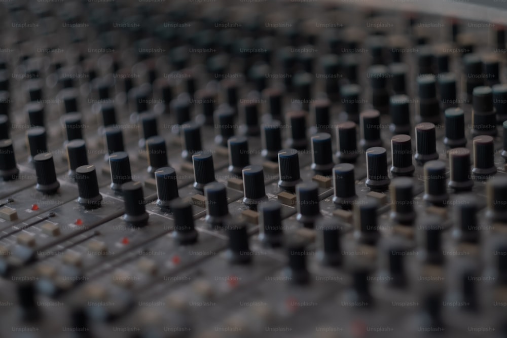 a close up of a sound board with many knobs