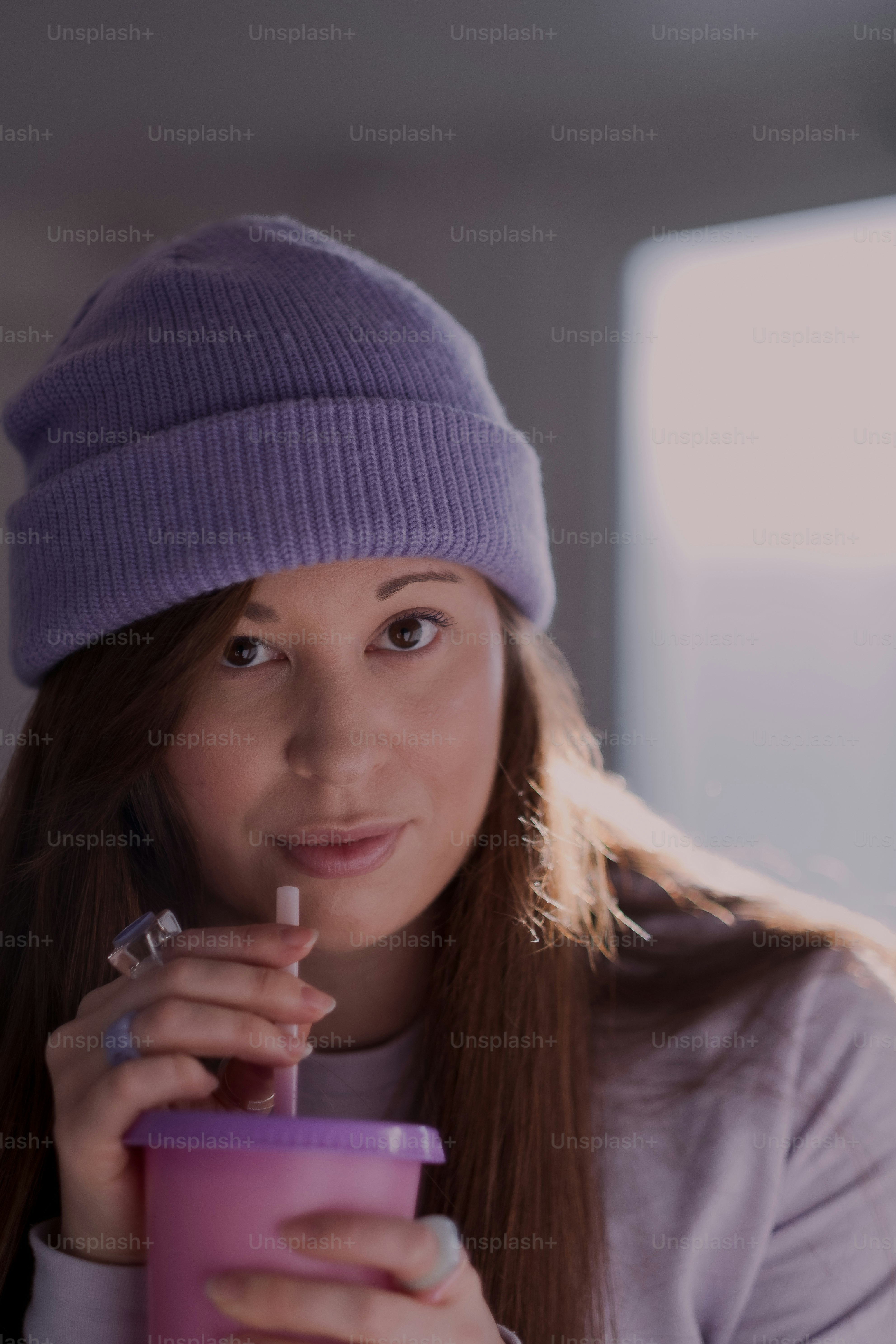 a woman wearing a hat and holding a cup