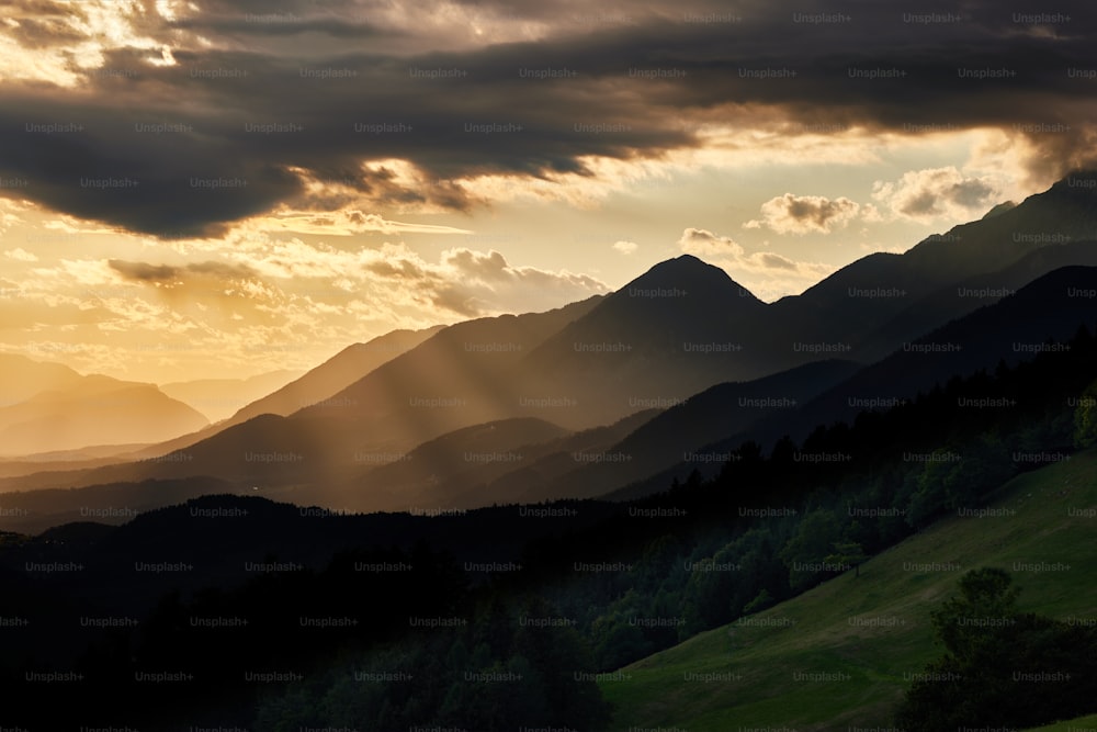 the sun is shining through the clouds over the mountains