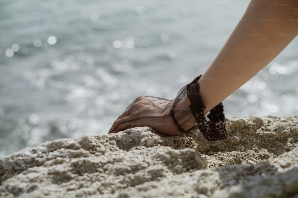 a person's feet sticking out of the sand on the beach
