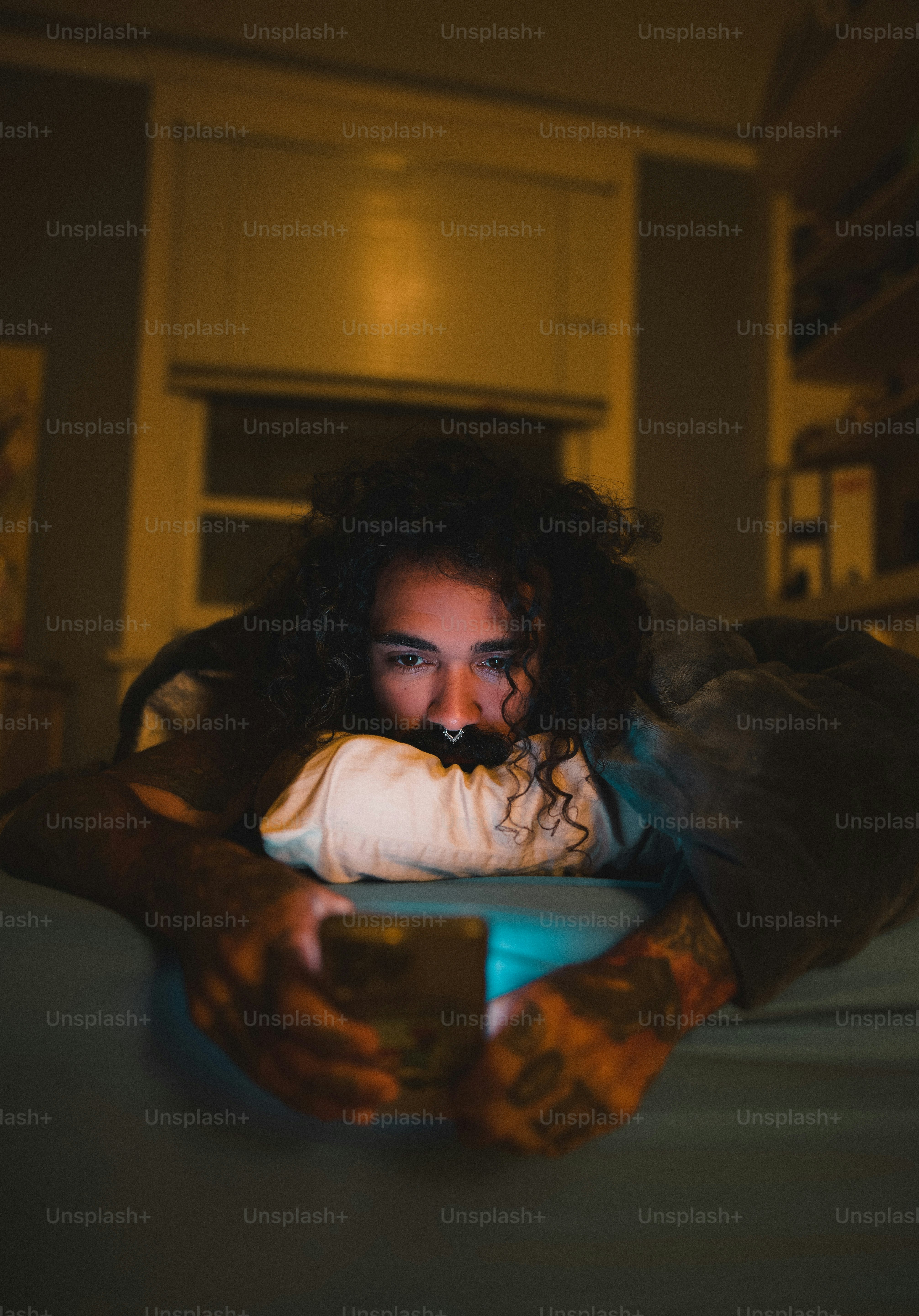 a person laying on a bed with a remote in their hand