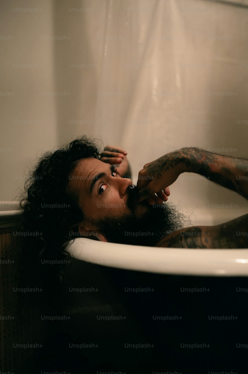 a woman in a bathtub with a tattoo on her arm