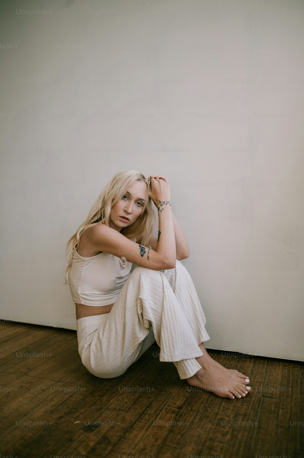 a woman sitting on the floor with her hands on her head