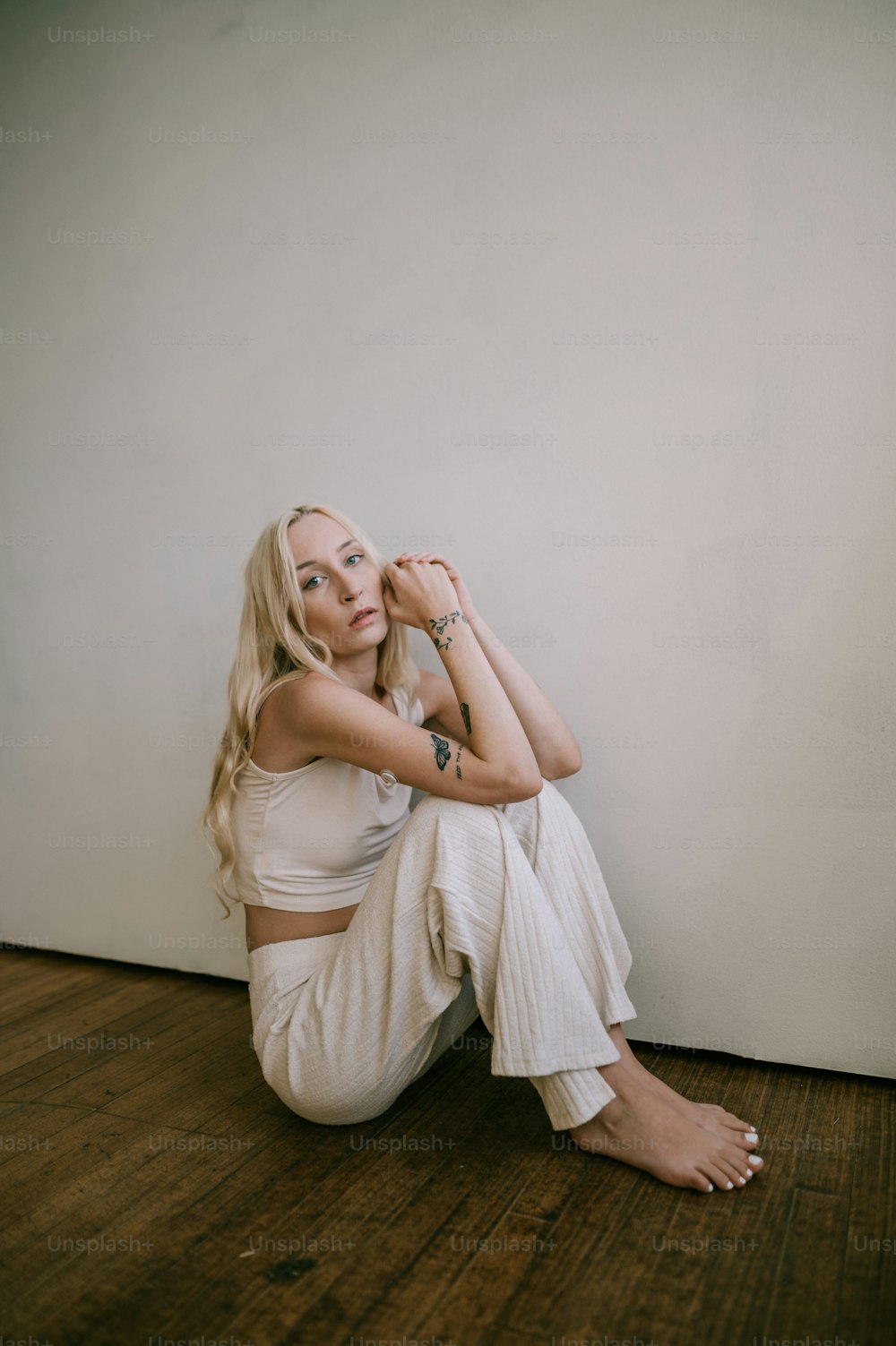 a woman sitting on the floor with her arms crossed