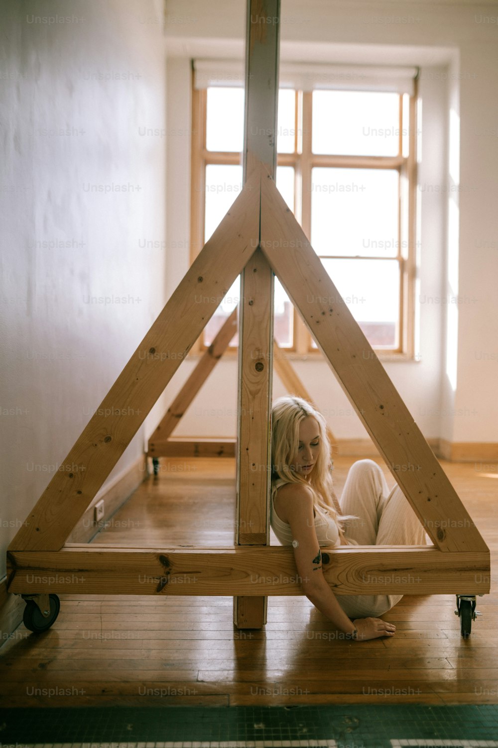 a woman laying on the floor in front of a wooden structure