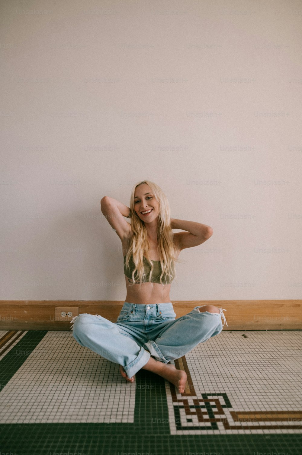 a woman sitting on the floor with her arms behind her head