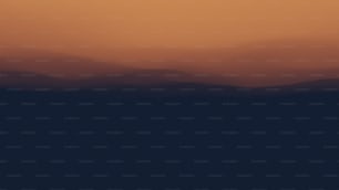 Un aereo che sorvola una catena montuosa al tramonto