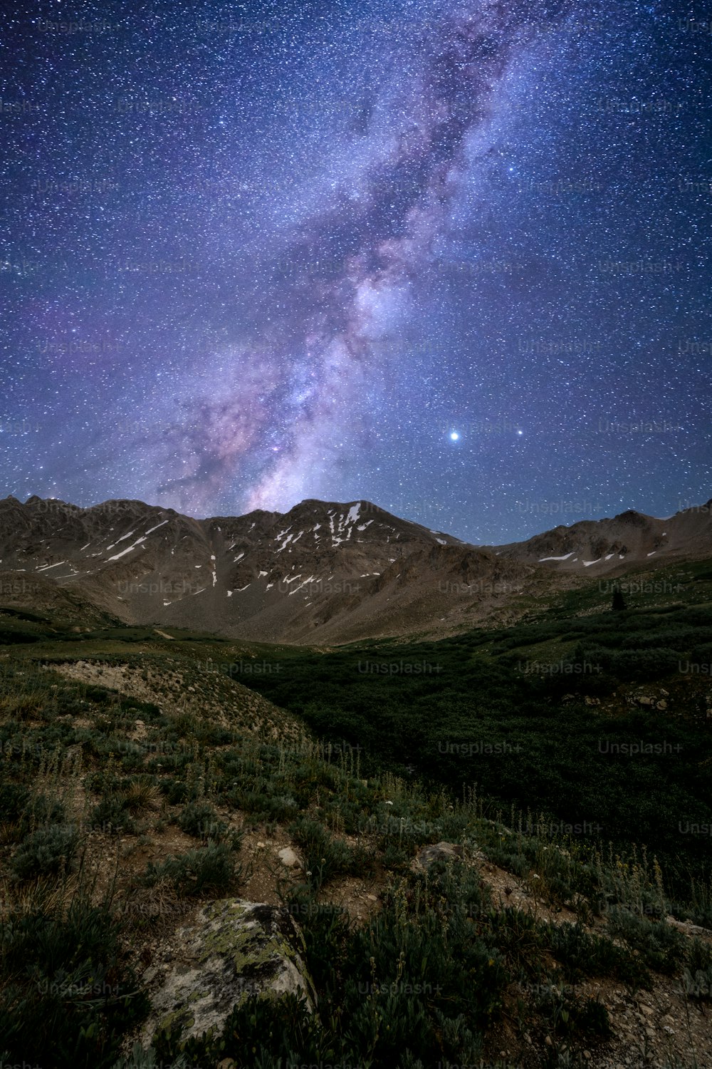 Der Nachthimmel ist mit Sternen über einer Bergkette gefüllt