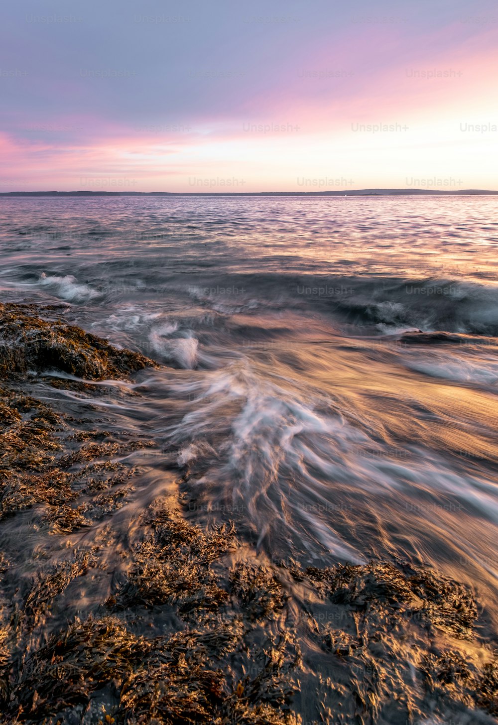 a view of a body of water with a sunset in the background