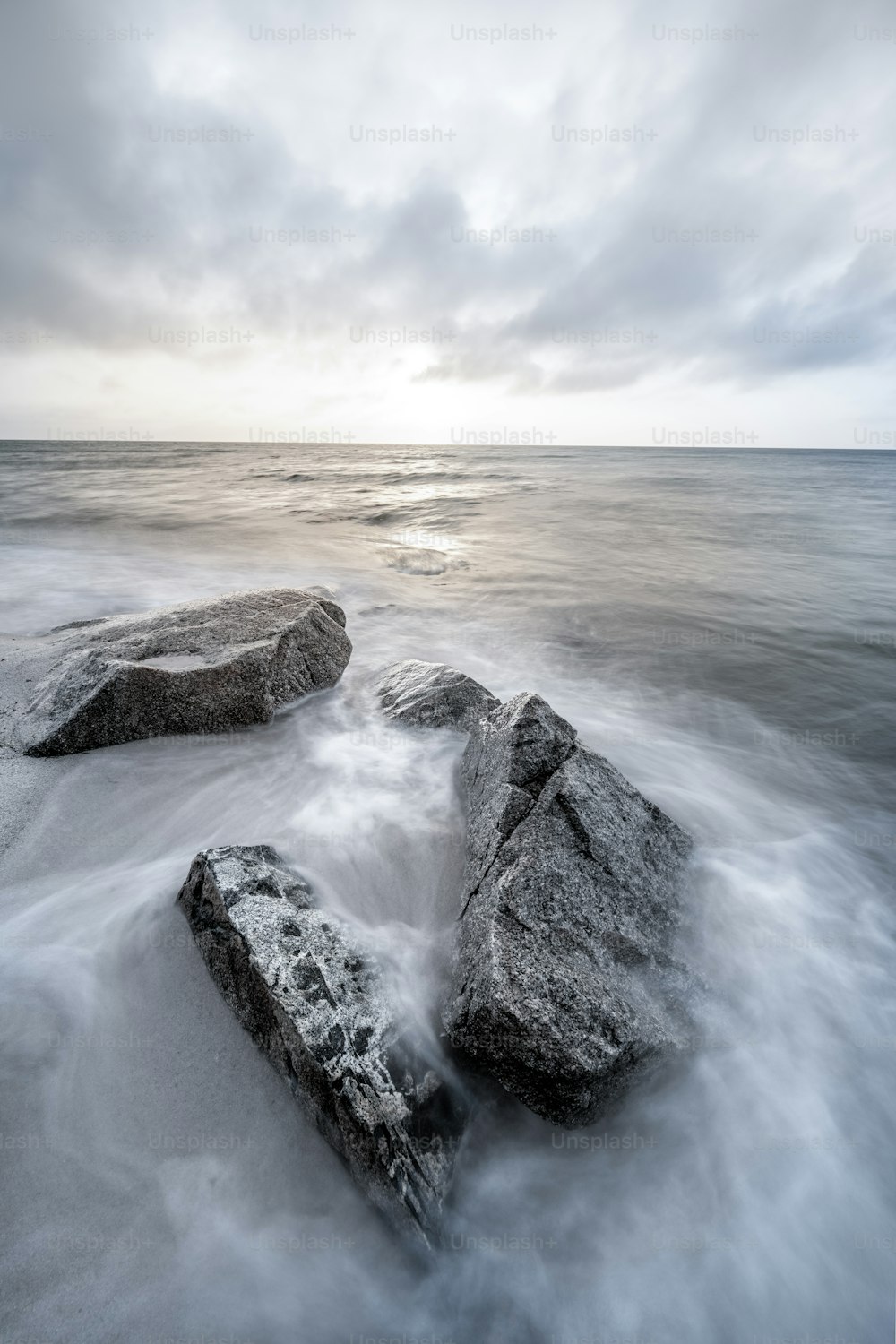 um par de rochas sentado em cima de uma praia de areia