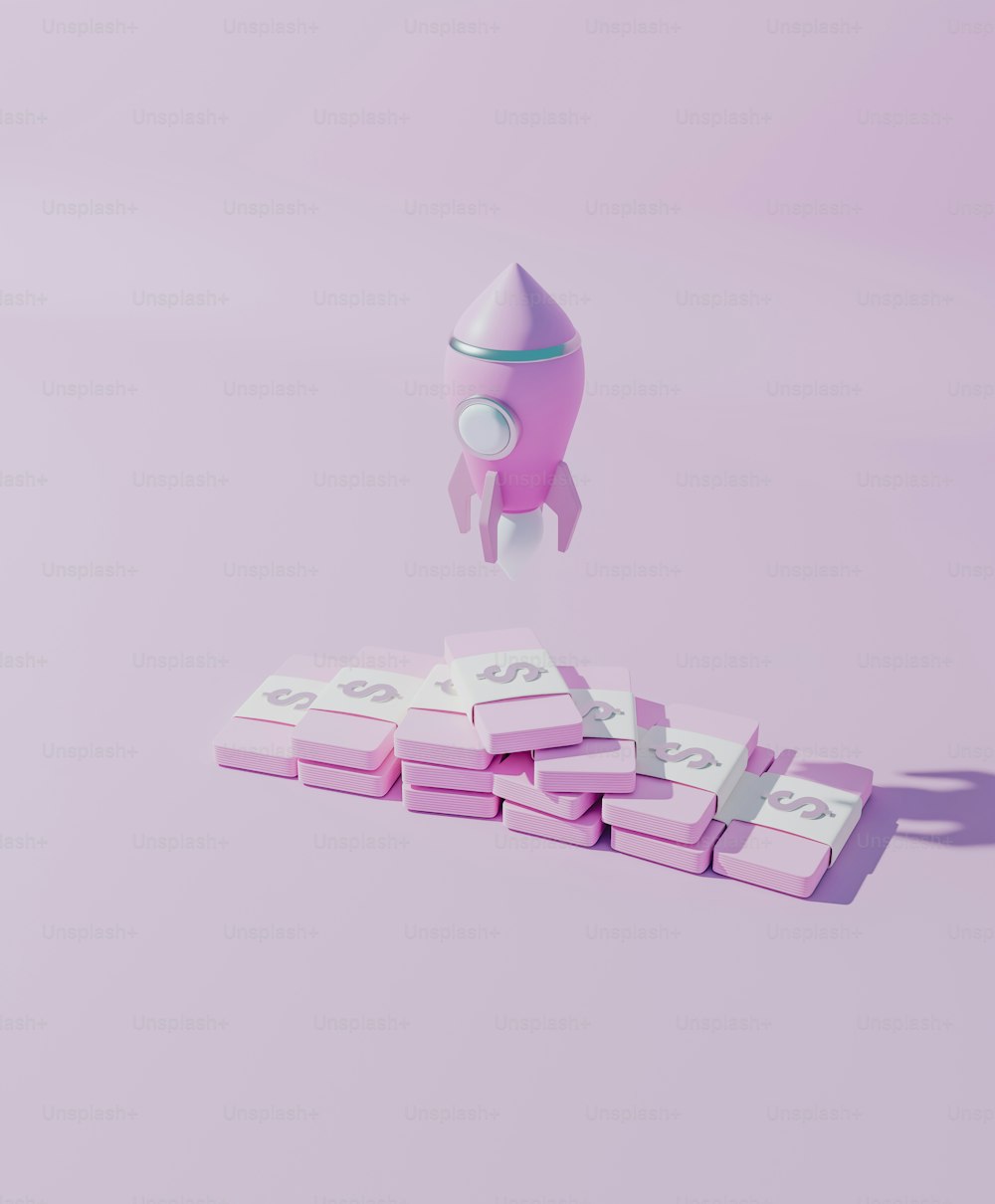 Um foguete de brinquedo está voando sobre uma pilha de blocos cor-de-rosa