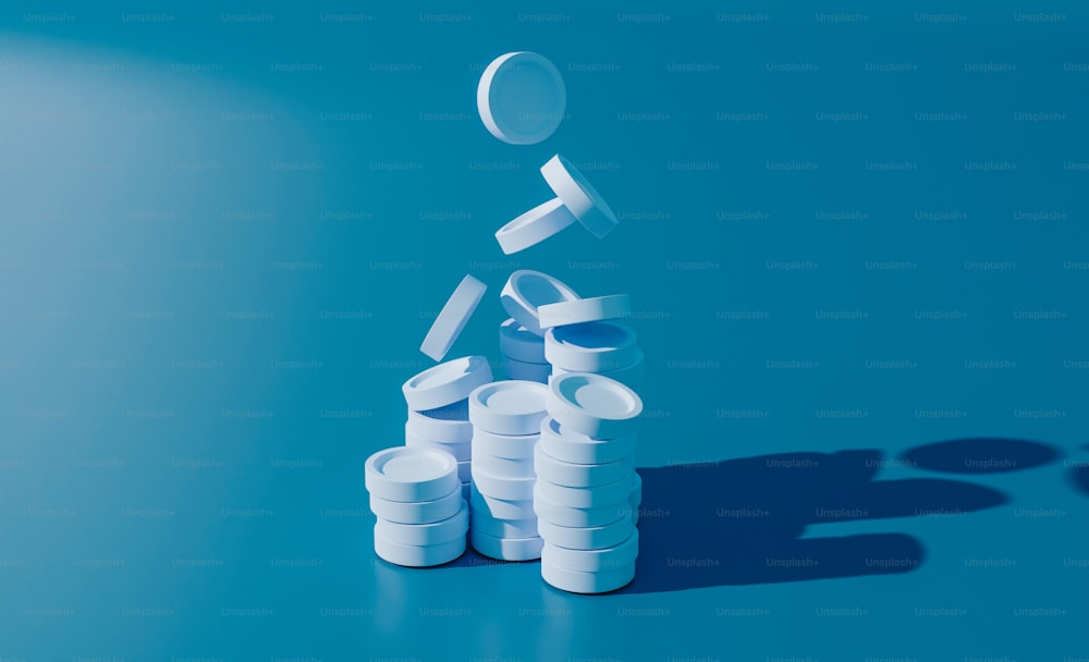 Una pila de píldoras sentadas encima de una mesa azul